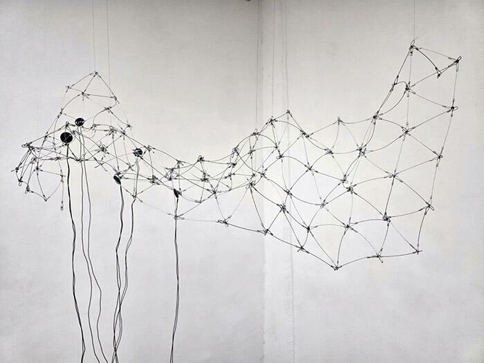Instalación sonora. Cable de acero, mini altavoces, sonido en bucle. Tamaño variable (aproximadamente 140 cm x 30 cm x 200 cm) Pieza Única. 2019