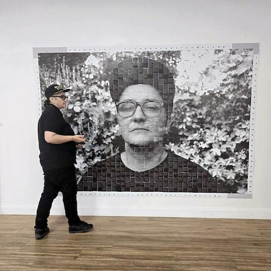 "Errancia" Autorretrato, impreso en papel en blanco y negro, en grandes dimensiones, emplazado sobre la pared a modo de mural. Instalación video interactiva. Obra a pared +.equipo de filmación para registro de sala permanente. TV . Activación del público retirando retazos de la obra. Medidas variables. 2025